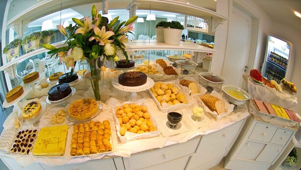 A buffet with various desserts and pastries, including cakes, cookies, and fruit.
