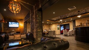 Un espace de détente moderne avec des canapés en cuir, une table basse en verre et un mur décoratif en pierre.