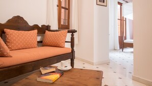 A cozy room with a wooden sofa, a coffee table, and a book. - Xenon Apartments (Chania)