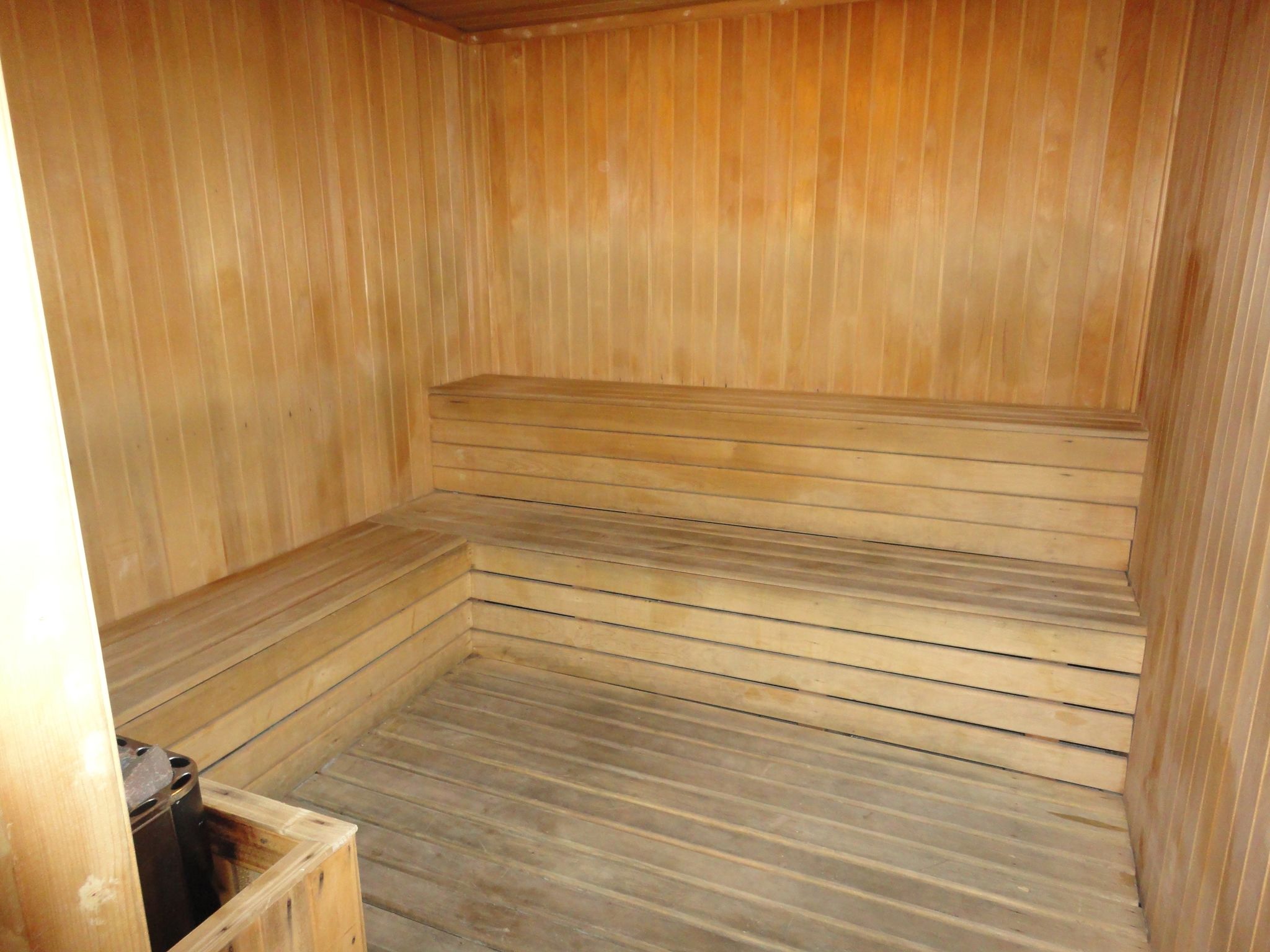 A wooden sauna with benches and a bench seat.