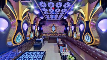 A luxurious interior with a central seating area, a stage, and a decorative ceiling.