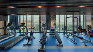 Ein Fitnessstudio mit Laufbändern, Crosstrainern und Gewichtsmaschinen.