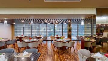 Ein modernes Restaurant mit Holzböden, mehreren Tischen und Stühlen.