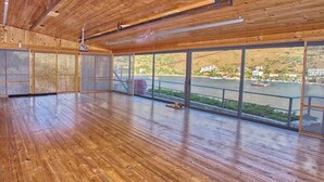 Amplia habitación con pisos de madera y grandes ventanales con vista al río.