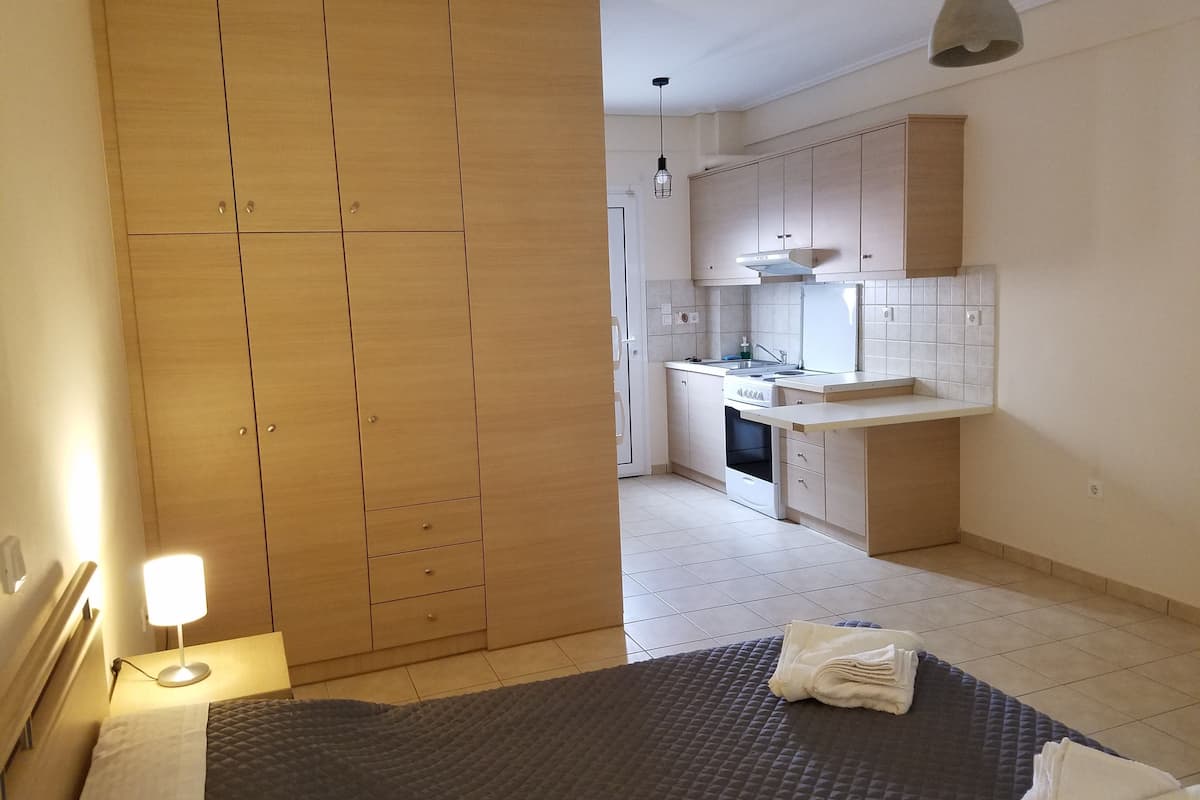 Un dormitorio con cama, lámpara de noche y baño con toalla.