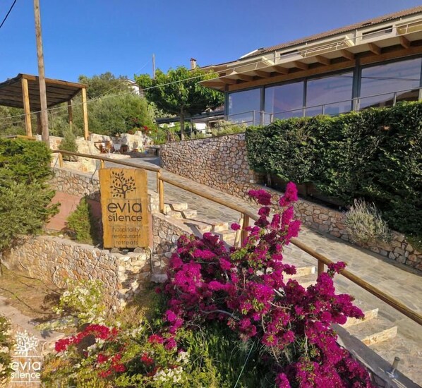 A sign for 'Evia Silence' hospitality, restaurant, and retreats.