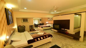 Habitación de hotel con cama, televisor, escritorio y una silla.