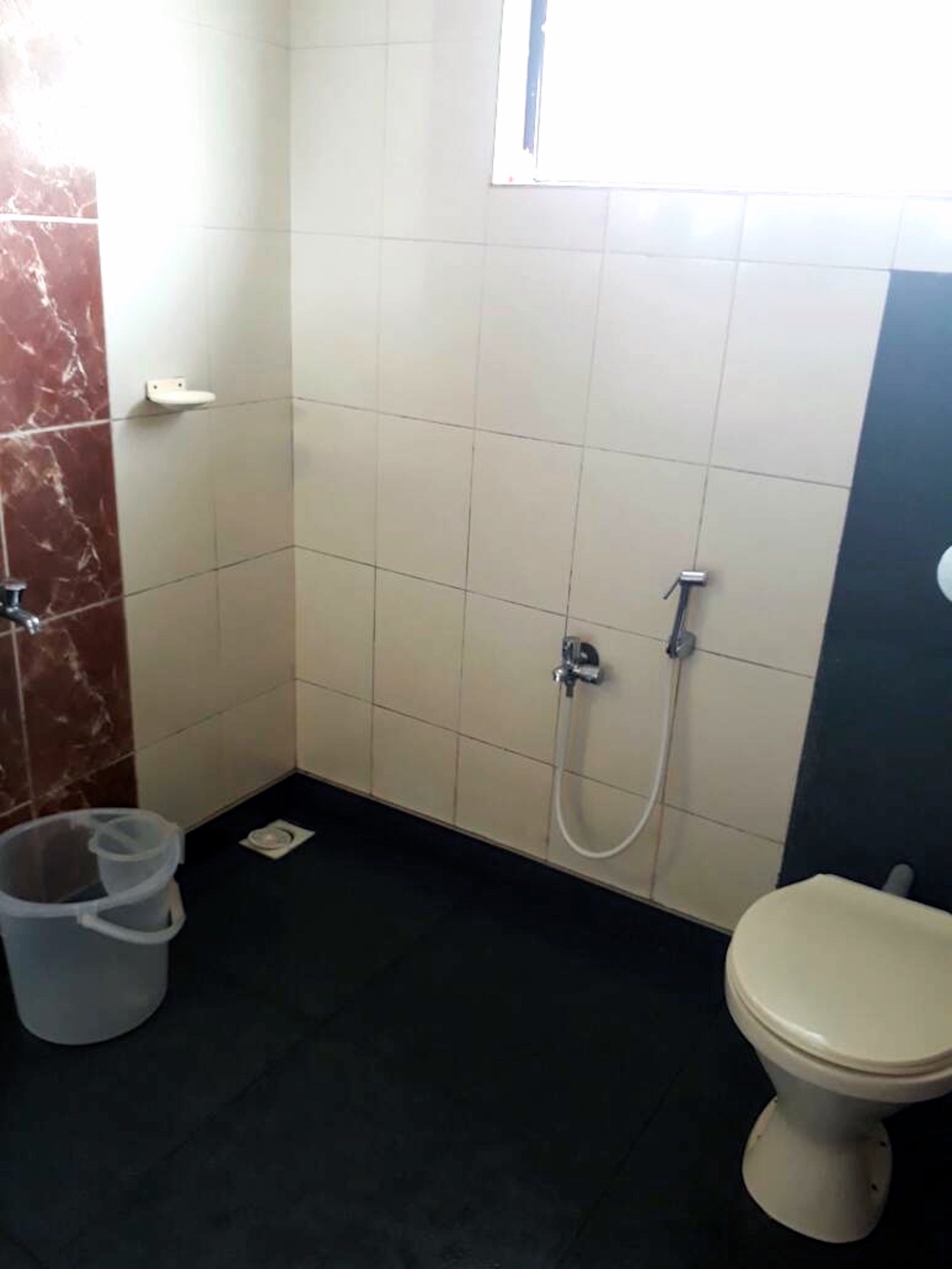 Un baño pequeño con inodoro, ducha y lavamanos.