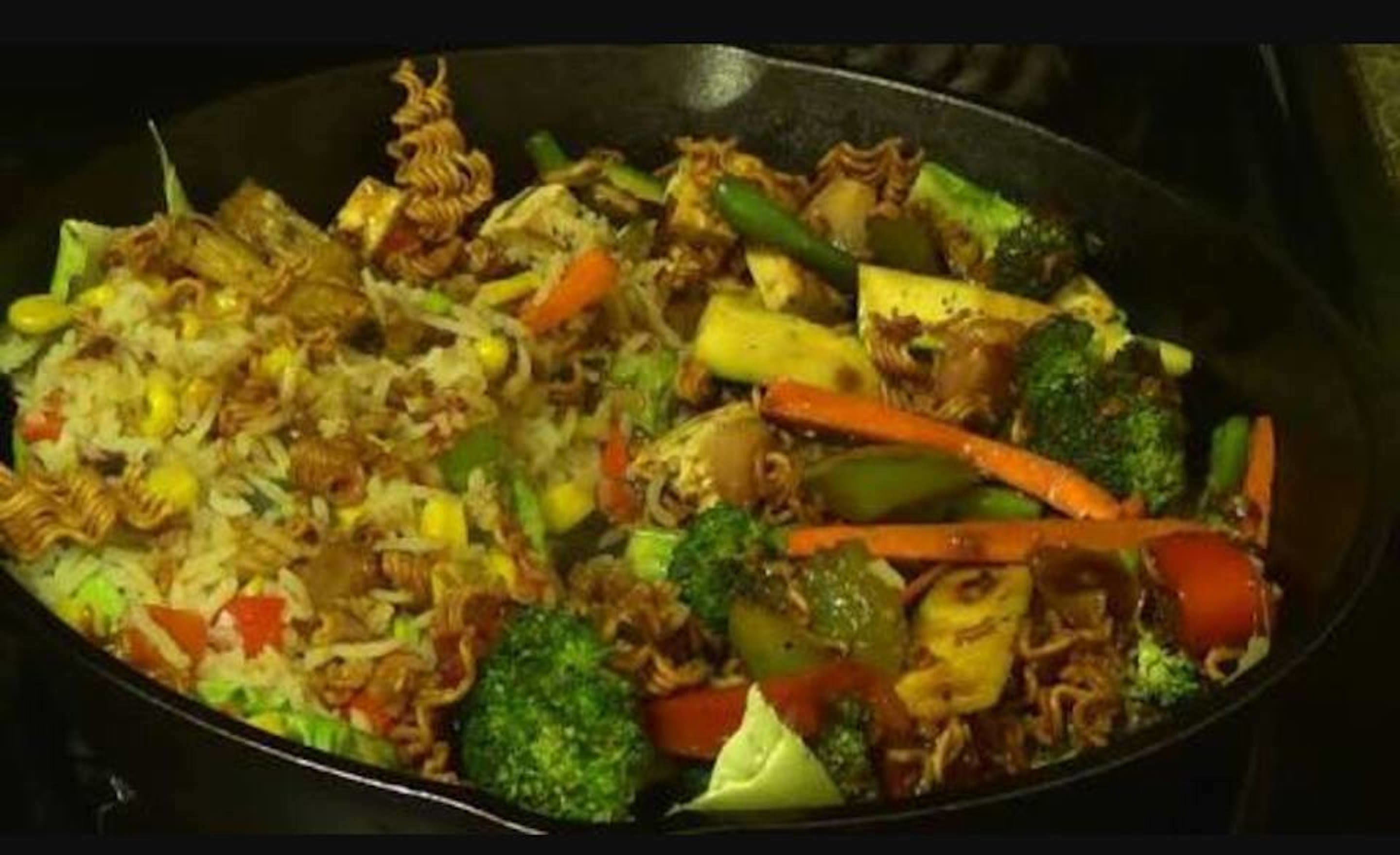 Zöldségekkel és tésztával készült, serpenyőben elkészített wok-étel.