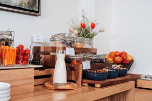 Buffet de l'esmorzar amb diverses opcions d'alimentació i un dispensador de llet.