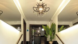 Una escalera con peldaños cubiertos de moqueta negra y peldaños de granito, que conduce a una zona de cocina.