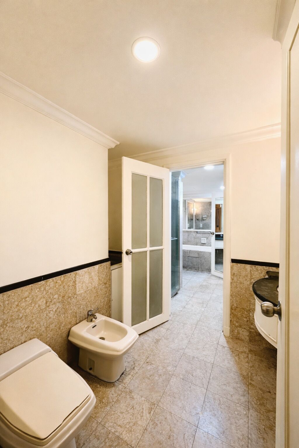 A bathroom with a toilet, bidet, and sink.