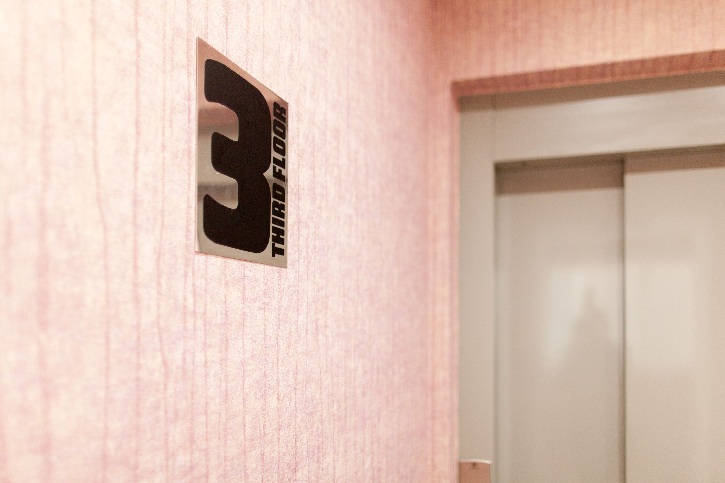 A wall with a sign indicating the third floor.