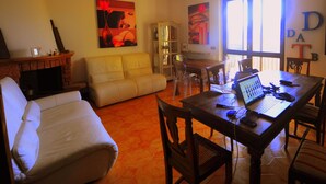 A living room with a sofa, a dining table with chairs, a fireplace, and artwork on the walls. - Bed & Breakfast La Dimora di Garlasco (Garlasco)