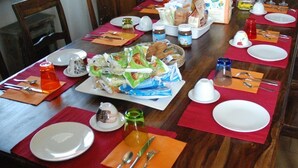A dining table set with plates, cutlery, and food items, indicating a meal setup in a dining area. - Bed & Breakfast La Dimora di Garlasco (Garlasco)