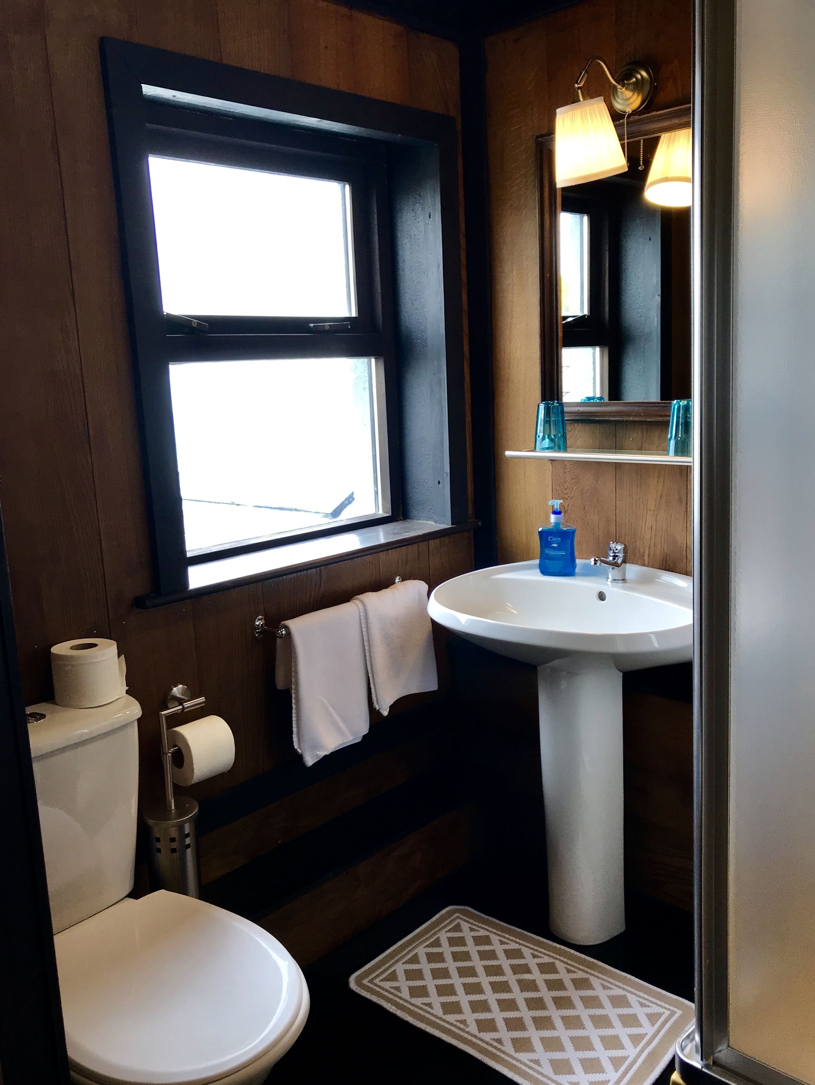 Un baño con inodoro, lavabo y ventana.