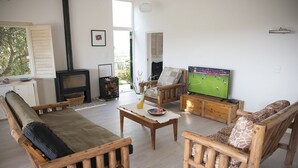 Una sala de estar acogedora con muebles de madera, un televisor y una chimenea.