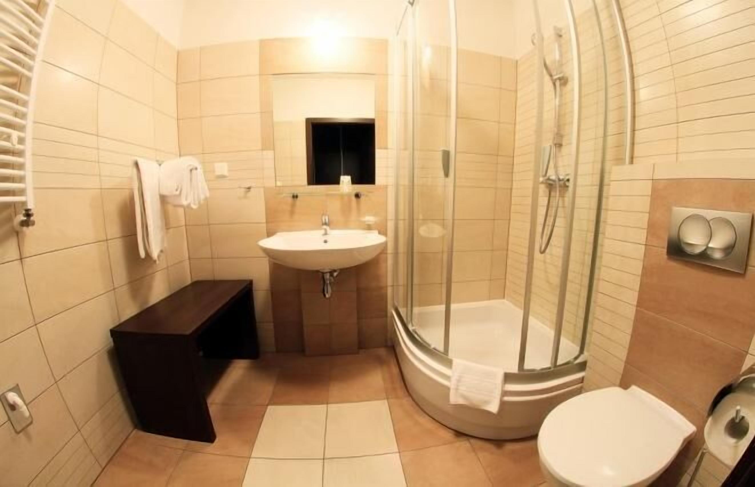 A bathroom with a sink, toilet, and glass-enclosed shower.