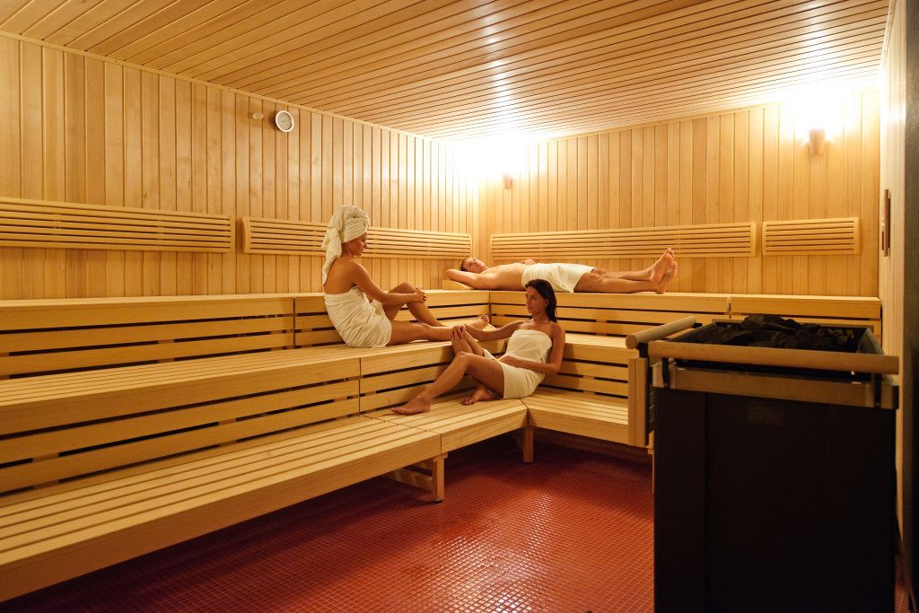 A sauna with wooden benches and a tiled floor.