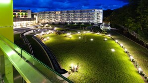 Een hotel met een goed verlichte binnentuin, moderne architectuur en een groot gebouw met meerdere verdiepingen.