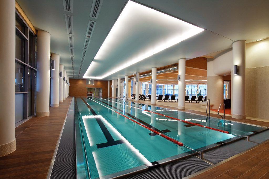 Una piscina con carriles definidos, rodeada de columnas y un suelo de madera.