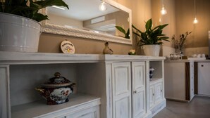 Een witte kast met een decoratief bord en een pot met bloemenmotief.