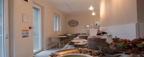 Spiseområde med borde, stole og et buffetbord.