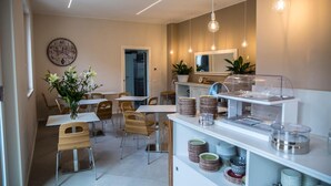 Een moderne eetruimte met een buffetopstelling, inclusief diverse gerechten en een klok aan de muur.
