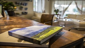 Een houten tafel met een boek getiteld 'Yungas' en een laptop.