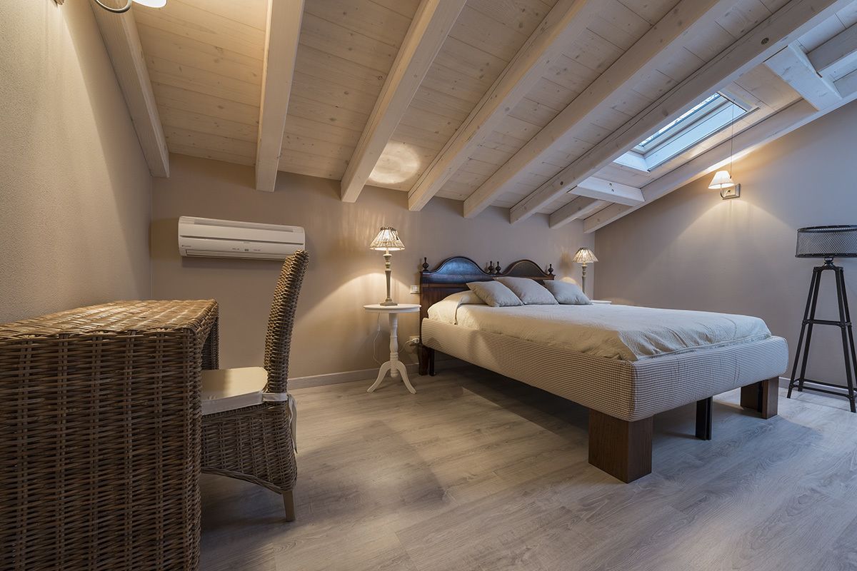 A bedroom with a bed, a chair, a table, and a lamp.