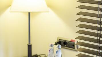 A hotel reception desk with a lamp, a telephone, a bottle, and a small decorative item.