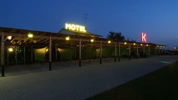Ein Motel mit überdachtem Außenbereich, einem gut sichtbaren Schild mit der Aufschrift 'MOTEL' und einem großen 'K'-Schild.