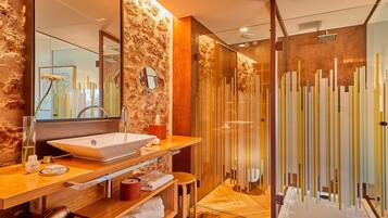 Une salle de bain moderne avec un grand lavabo, un miroir et une douche à l’italienne.