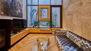 Una sala de estar moderna con un ventanal grande, un sofá, una mesa de centro y un televisor.