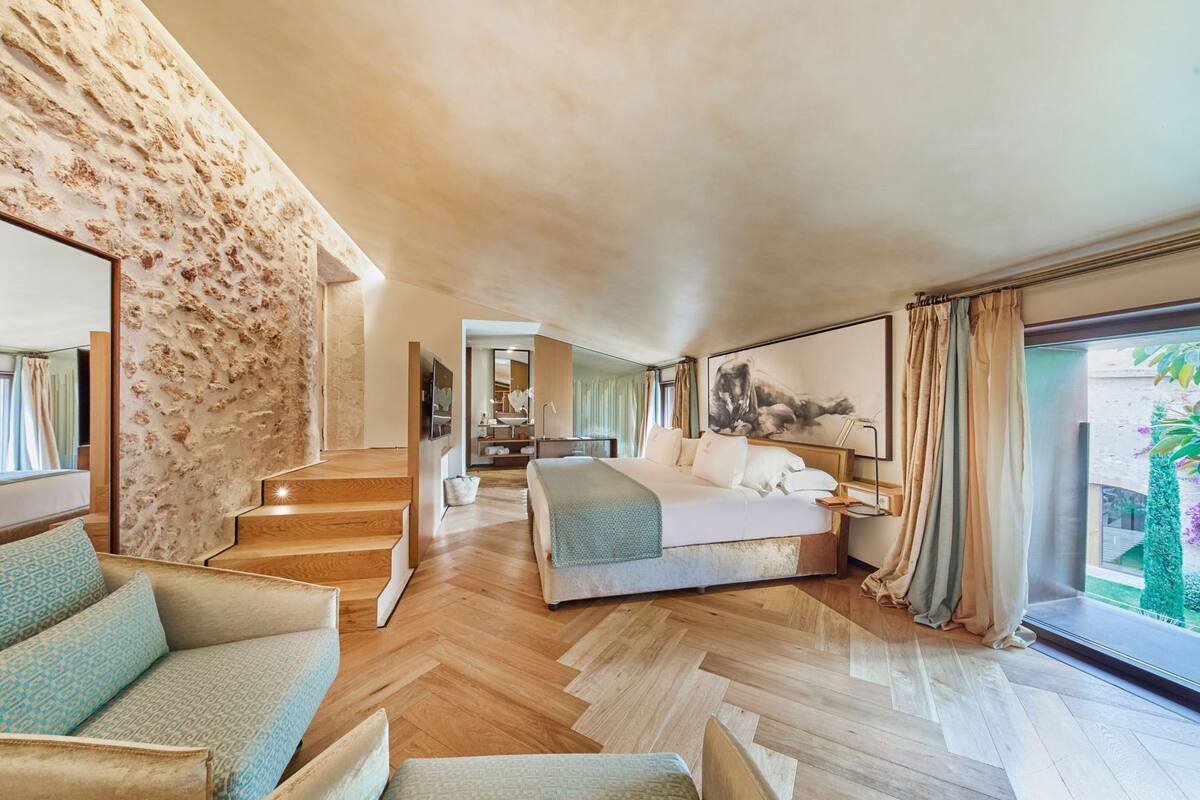 Une chambre moderne avec un grand lit, un escalier et une vue sur l’extérieur.