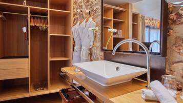Un baño moderno con un espejo grande, tocador de madera y estantes empotrados.