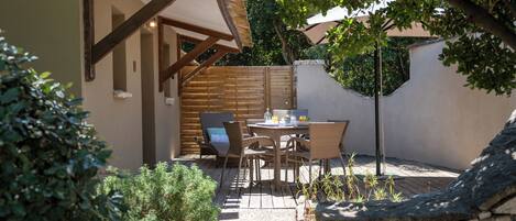 A patio with a table and chairs, a stone wall, and a wooden fence.