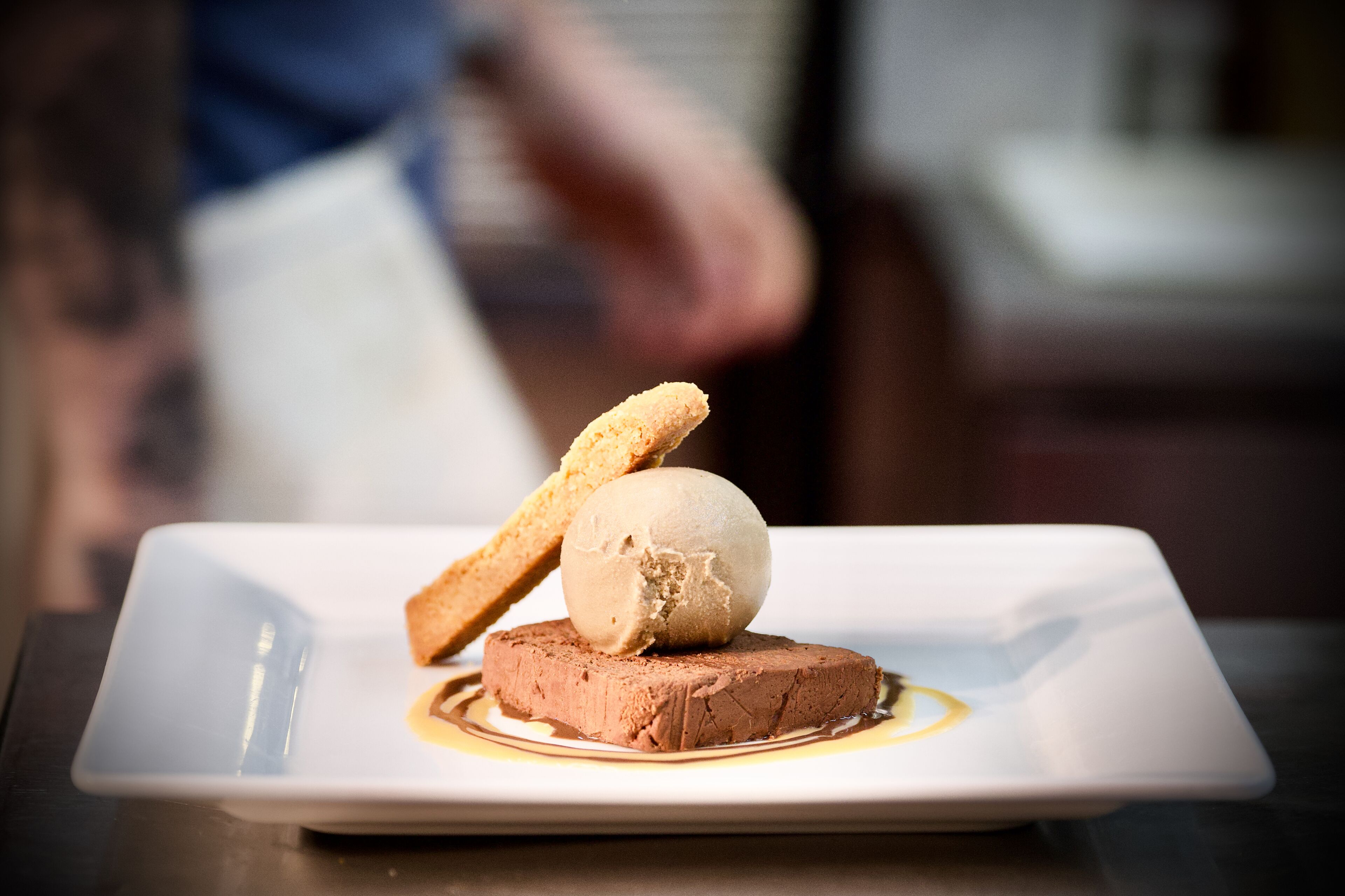 En dessert på en fyrkantig tallrik med en suddig bakgrund.