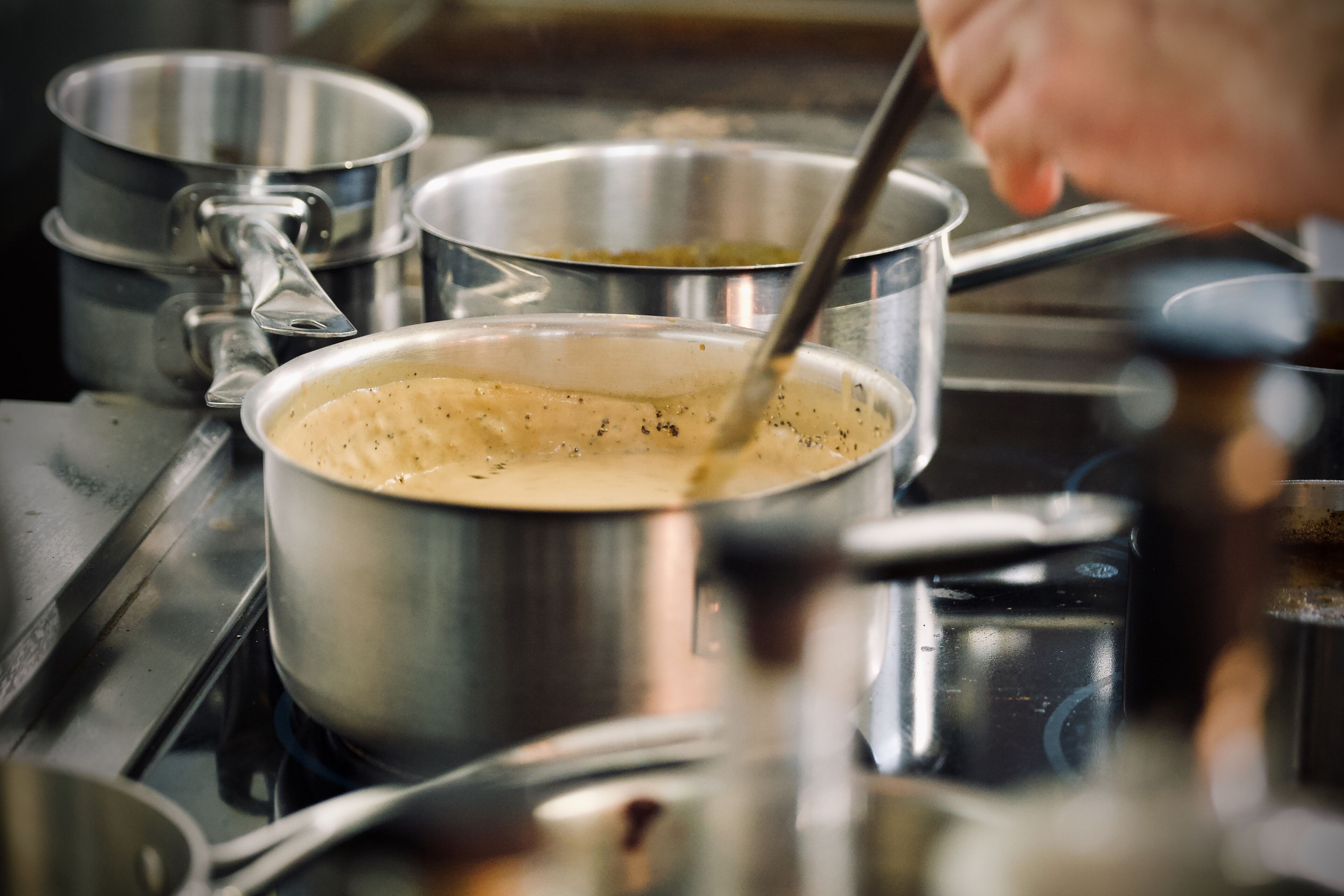 A kitchen with stainless steel pots and pans on a stove.