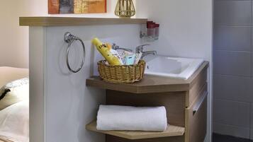 Un baño moderno con tocador de madera, lavamanos blanco y toallero.