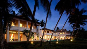 A two-story resort with multiple rooms and a swimming pool, surrounded by palm trees. - Sri Villas (Induruwa)