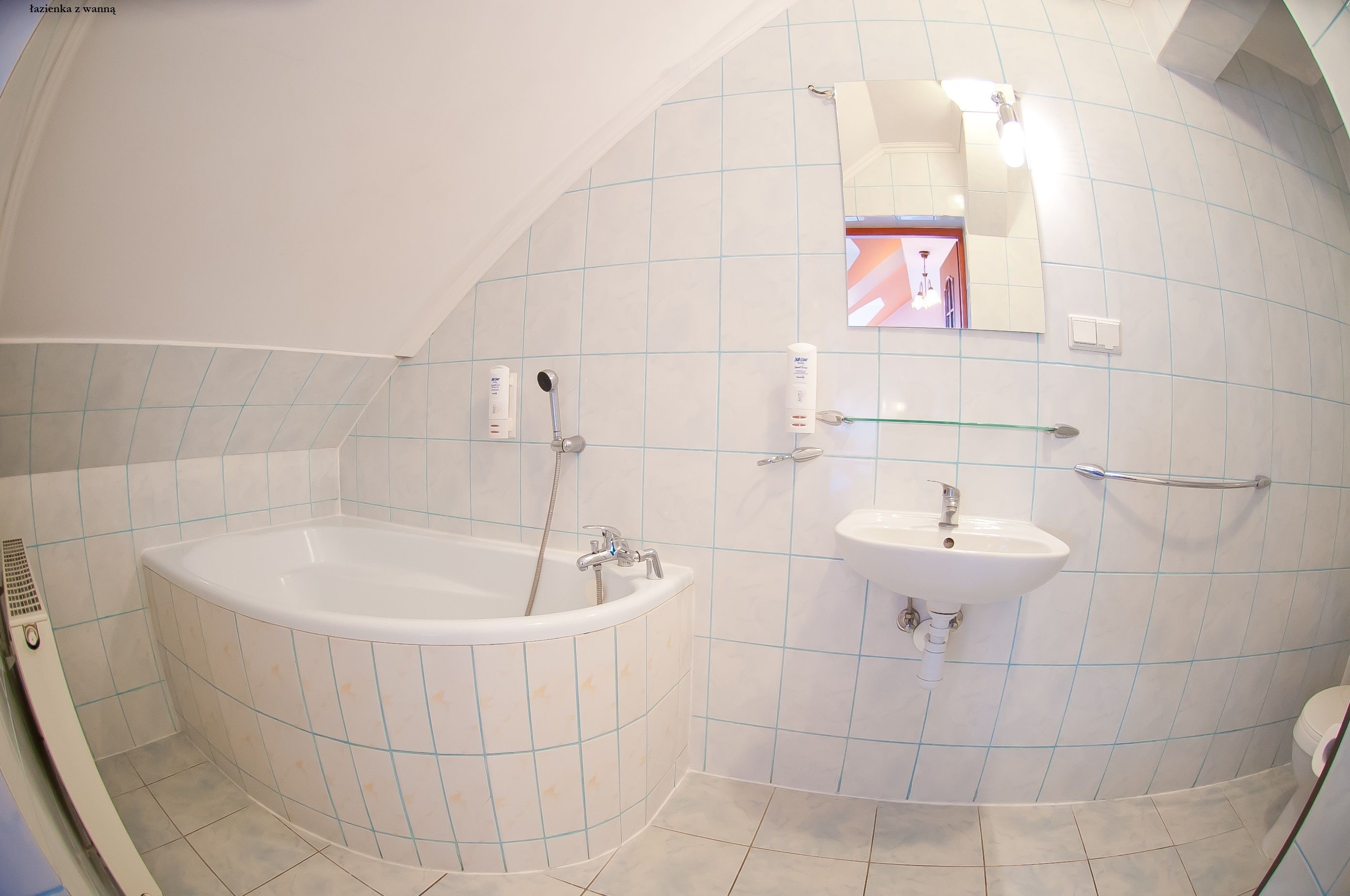 Een badkamer met een bad, een wastafel en een klein raam.