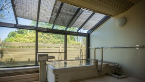 Eine Sauna mit Holzbank, Glasdach und Blick ins Freie.