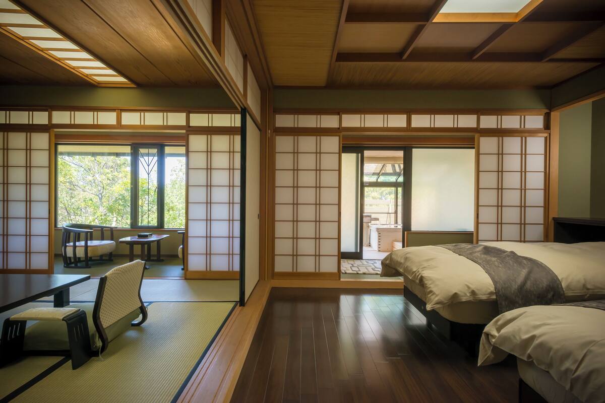 Une pièce de style japonais traditionnel, avec un sol recouvert de tatamis, une table basse et un futon servant de lit.