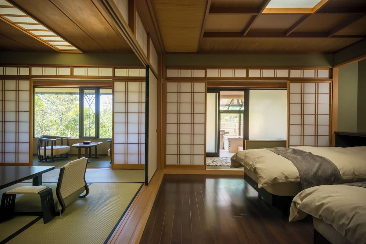 Una habitación tradicional japonesa con suelo de tatami, una mesa baja y un futón.
