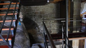 Un muro de piedra con una escalera de madera y barandillas de metal.