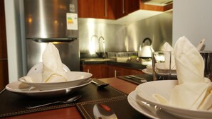 Una mesa puesta con platos, servilletas, cubiertos y una copa.