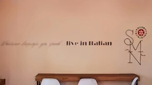 A room with a bed, a wall with a decorative sign, and pendant lights. - B&B Santa Maria Novella (Florence)