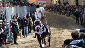 Evento de carreras de caballos con espectadores y una pista de tierra.