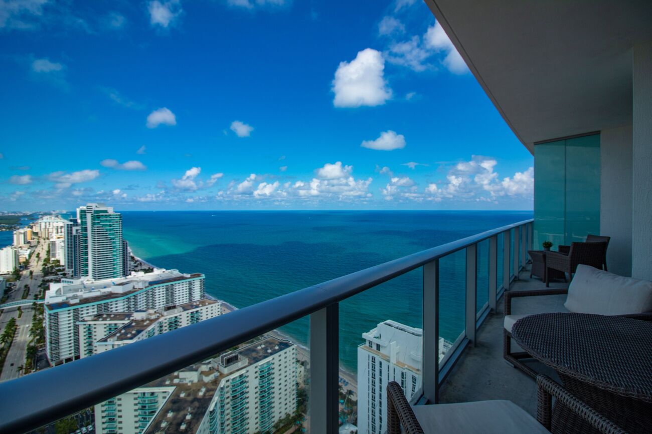 A balcony with a view of the ocean and cityscape.
